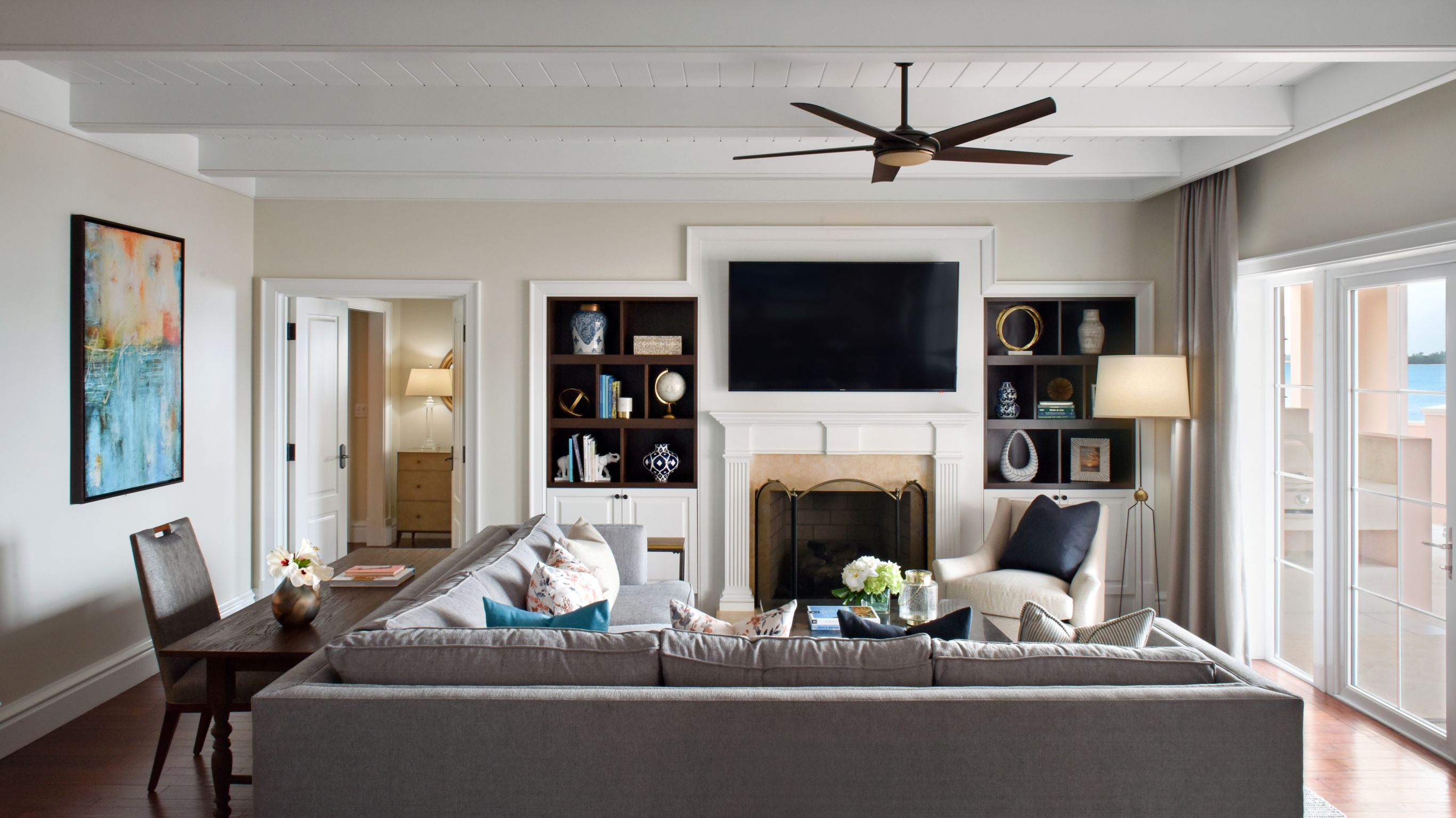 Residence Living Area with desk to the left, TV and fireplace, and balcony terrace to right.